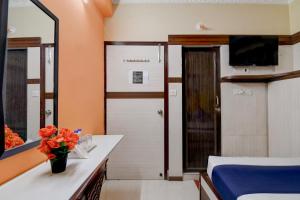 a room with a bed and a bathroom with a mirror at Avinaav Inn in New Town