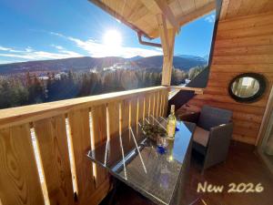a glass table on the balcony of a cabin at Almhütte Grosserhütte in Katschwald +21 photos