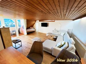 a living room with a white couch and a wooden ceiling at Almhütte Grosserhütte in Katschwald