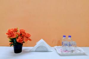 a table with a vase of flowers and two bottles of water at Avinaav Inn in New Town +17 photos