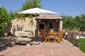 a patio with an umbrella and a table and chairs at Quinta da Sardinha in Elvas