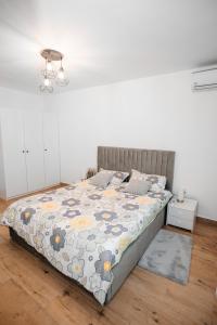a bedroom with a bed with a floral comforter at Sunset Studio Valcea in Râmnicu Vâlcea