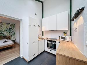 a kitchen with white cabinets and a counter top at Le Forum - Appartement rare - Parking privé - Centre - Reims in Reims