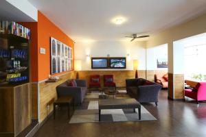 a lobby with chairs and a waiting room with orange walls at Casa Andina Standard Miraflores San Antonio in Lima