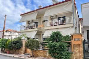 a white building with trees in front of it at Villa Leonidas in Nea Vrasna