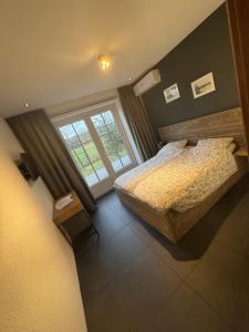 a bedroom with a bed and a large window at Jaegershoes in Belfeld