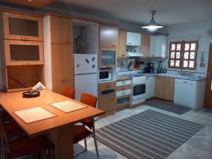 a kitchen with a table and a white refrigerator at Στουντιο στο Πανοραμα in Thessaloniki