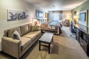 a hotel room with a bed and a couch at Sleep Inn & Suites East Syracuse in East Syracuse