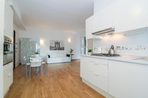 uma cozinha com armários brancos e uma sala de jantar em The Best Rent - Fiera Milano City Apartment em Milão