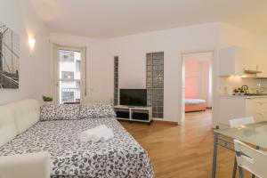 uma sala de estar com uma cama e uma cozinha em The Best Rent - Fiera Milano City Apartment em Milão