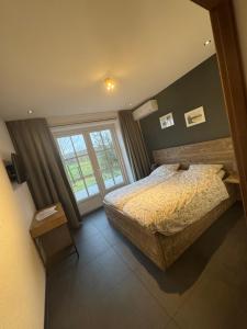 a bedroom with a bed and a large window at Jaegershoes in Belfeld