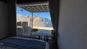 a room with a window with a view of the mountain at Al khitaym guest house in Sa‘ab Banī Khamīs