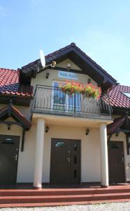 a house with a balcony with flowers on it at Willa Patio in Stegna