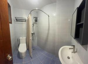 a bathroom with a toilet and a sink at Apt101 Guest House in Bacoor