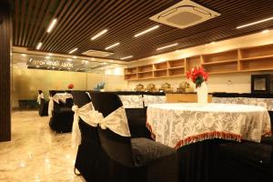 a dining room with a table and chairs with white table cloth at Royal Raven Hotel & Banquet' Greater Noida Nearby India Expo Centre & Mart in Greater Noida