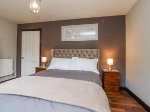a bedroom with a large bed with two night stands at Baywood Cottage in Keighley