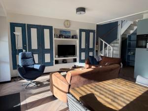 a living room with a couch and a chair at Gastenverblijf Neeltje in Oostkapelle