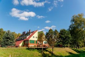 a large house on a hill in a field at Park Inn Resort in Mirosławiec