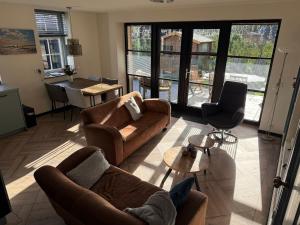 a living room with a couch and chairs and a table at Gastenverblijf Neeltje in Oostkapelle