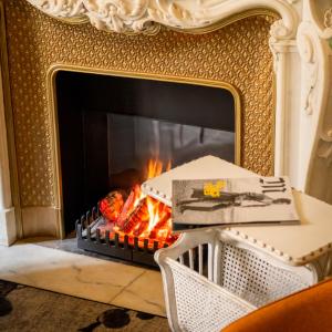 ein Kamin in einem Wohnzimmer mit Feuer in der Unterkunft Hôtel Vendôme in Nizza + 55 Fotos