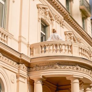 eine Statue auf dem Balkon eines Gebäudes in der Unterkunft Hôtel Vendôme in Nizza