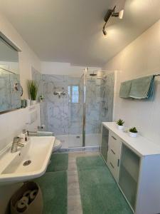 a bathroom with a white sink and a shower at Ferienwohnung Heidi mit Oberstaufen PLUS in Oberstaufen +43 photos