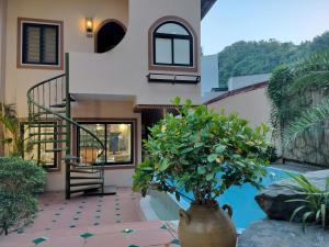 a house with a staircase and a vase with a plant at Catba Garden Camellia in Cat Ba