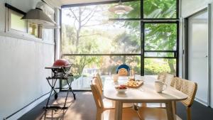 a table and chairs in a room with a large window at Pocheon luxjay pet Pension in Pocheon