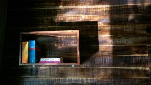 a shelf with books on a wooden wall at Hang Lan Ecolodge in Ninh Binh