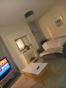 a living room with a couch and a tv and a table at 3 Bedroom Apartment near the Beach in South Shields