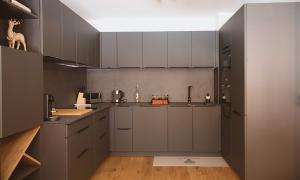 a kitchen with gray cabinets and a counter top at La Moutonniere in Levassaix