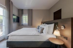 a bedroom with a large white bed and a window at Hotel Magdalener Hof in Bolzano