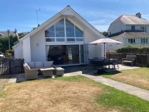 a house with a patio with a table and an umbrella at Awel Deg in Pembrokeshire
