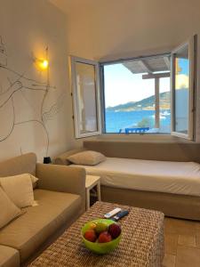 a living room with a couch and a bowl of fruit on a table at Heliotropio Studios & Apartments in Pollonia