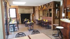 restauracja ze stołami i krzesłami oraz kominkiem w obiekcie Hostellerie des Colonnes w mieście La Force