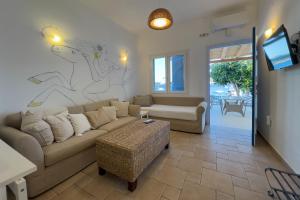 a living room with a couch and a tv at Heliotropio Studios & Apartments in Pollonia