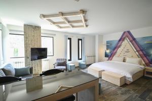 a bedroom with a bed and a tv in it at Arawan - Boutique Art Hotel - Tannourine in Batroûn