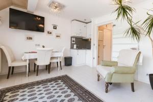 a living room with a table and chairs and a kitchen at Čarman House in Bled