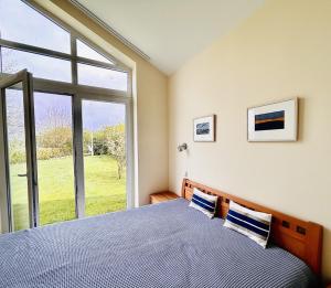 a bedroom with a bed and a large window at Kapitän Hansen Haus in Kosel +21 photos