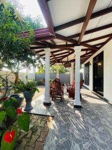 an outdoor patio with a wooden pergola at Sasanda Villa in Weligama