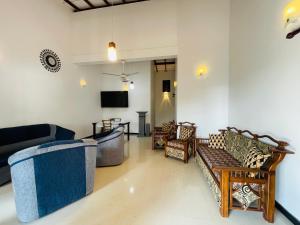 a living room with couches and a flat screen tv at Sasanda Villa in Weligama