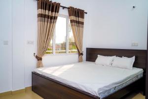 a bedroom with a large bed with a window at Birunthavanam in Vavuniya