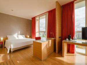 a hotel room with a bed and a large window at B&B HOTEL Remilia in Reggio Emilia