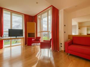 a living room with red furniture and a flat screen tv at B&B HOTEL Remilia in Reggio Emilia +21 photos