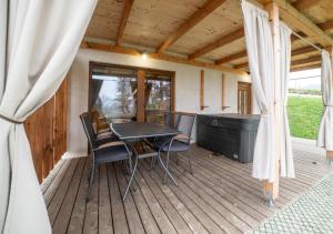 a patio with a table and chairs on a deck at Glamping Podgoro with private hot tube - Rogatec in Rogatec