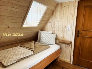 a bed in a log cabin with a window at Almhütte Ödenhübl in Katschwald +21 photos