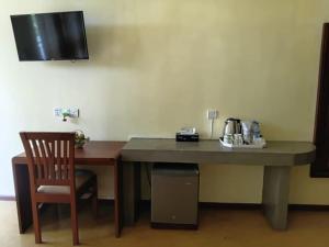 a desk with a chair and a table with a microwave at Villa Rustic in Negombo