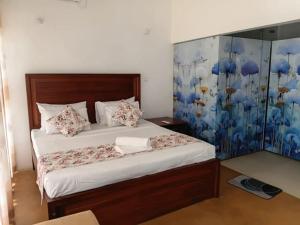 a bedroom with a bed with a blue and white wall at Villa Rustic in Negombo