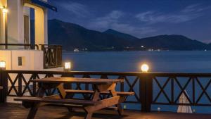 a table and bench on a balcony with a view of the water at Namhae Opera House Pension in Namhae +4 photos