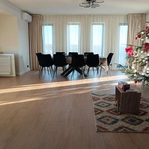ein Esszimmer mit Tisch und Stühlen und einem Weihnachtsbaum in der Unterkunft Avabi Concept in Nenciu